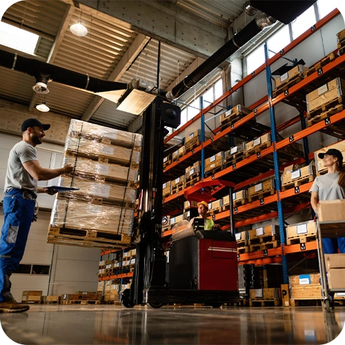 Opérateurs déchargeant une palette dans un entrepôt logistique
